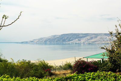 Scenic view of sea and mountains against sky