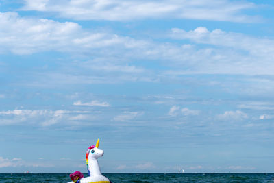 Rear view of man in sea against sky