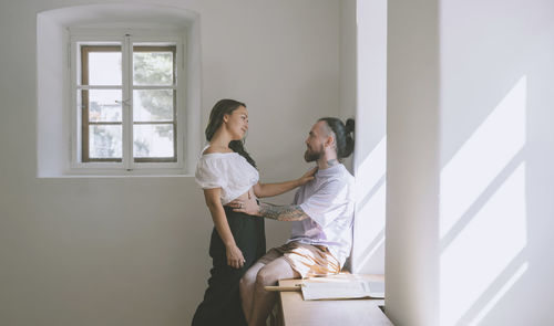 Romantic hipster couple by wall at home