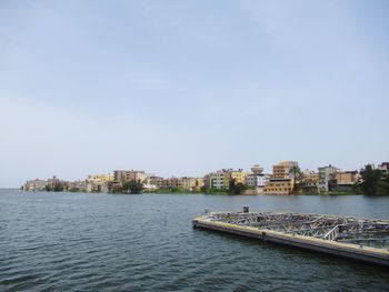 Scenic view of sea by buildings against sky