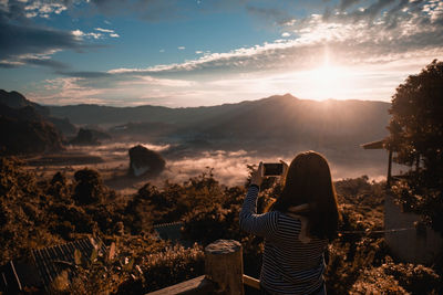 Man photographing at sunset