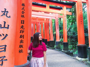 Full length of woman standing against orange wall