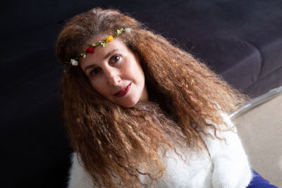 Portrait of woman wearing flowers indoors