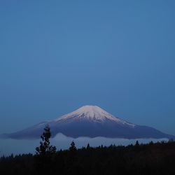 Scenic view of snowcapped mountain against blue sky