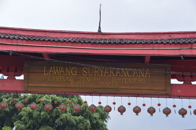 Low angle view of text on roof against sky