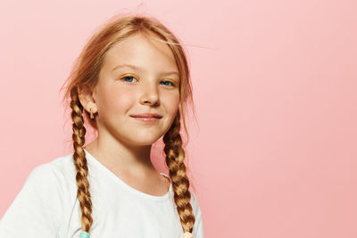 Portrait of young woman against pink background