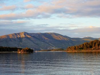 Scenic view of lake by mountains against sky