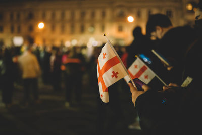 Cropped hands of woman holding flag