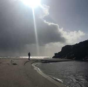 Silhouette man on beach against sky