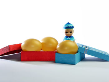 Close-up of toys on table against white background