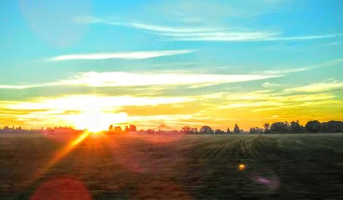 Scenic view of sunset over field