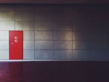 Red door on tiled wall in building