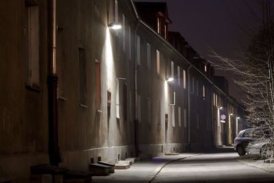 Illuminated street amidst buildings at night