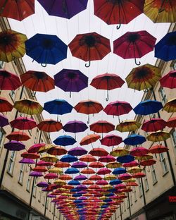 Low angle view of multi colored umbrellas hanging in row