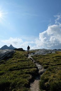 Rear view of man on mountain against sky