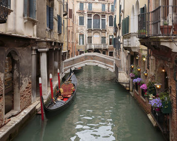 Boats in canal amidst buildings in city