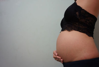 Midsection of woman standing against wall