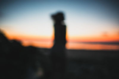 Silhouette man standing against sky during sunset