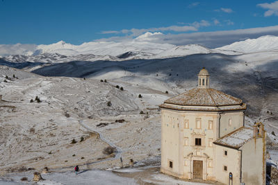 Ancient fortification and small church in the snowy mountains of abruzzo, italy