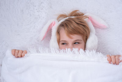 Portrait of young woman lying on bed