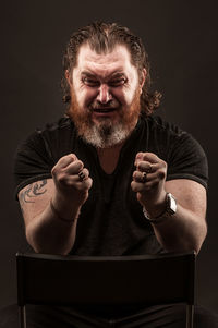 Portrait of worried man against black background