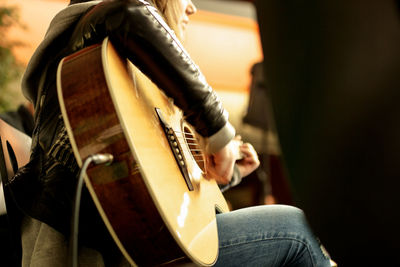 Midsection of girl holding guitar