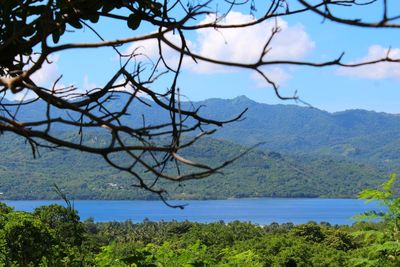 Scenic view of sea and mountains against sky