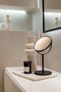 A corner of stylish bathroom with accessories. table with mirror, candle and ceramic vase