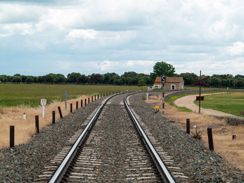 Railroad tracks on field against sky