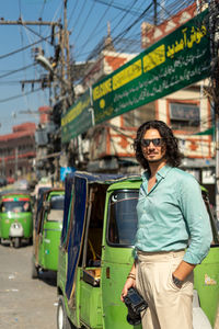 Portrait of young woman standing in city