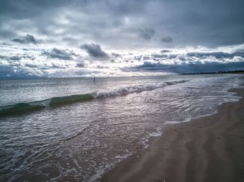 View of beach against cloudy sky