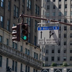 Low angle view of road signal against buildings