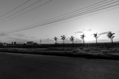 Electricity pylons on field against sky