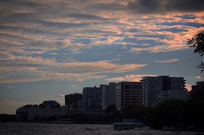 Buildings in city against cloudy sky