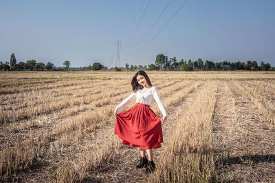 Woman with umbrella on field