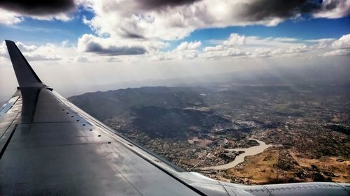 Cropped image of airplane wing over landscape