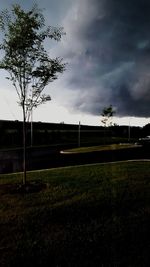 Scenic view of grassy field against cloudy sky