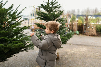 Portrait of young man standing against plants