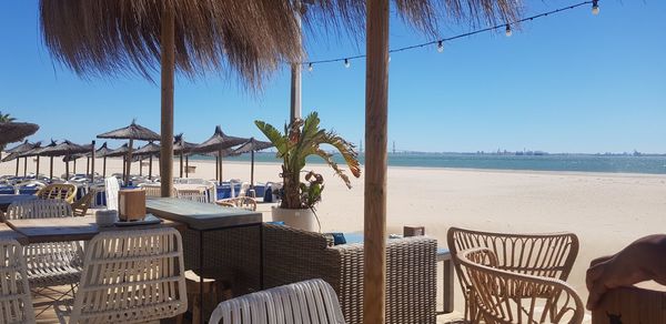 Empty chairs and tables at beach