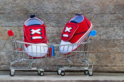 Close-up of red shoes in shopping carts against wall
