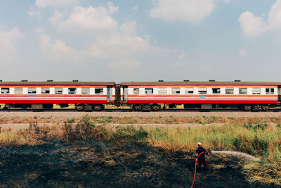 Man standing by train against sky