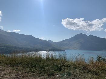 Scenic view of lake by mountains against sky