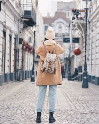 Rear view of woman standing on street