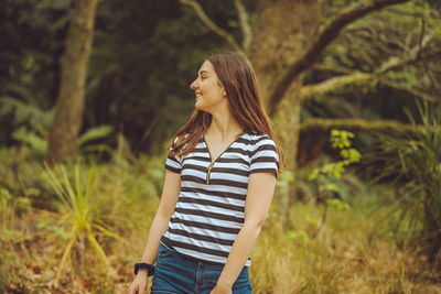 Young woman standing in forest