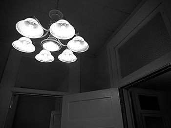 Low angle view of illuminated lamp hanging on ceiling at night