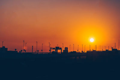 Silhouette buildings against sky during sunset