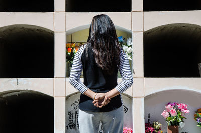 Rear view of woman standing against window