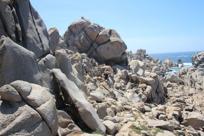 Rocks on beach against clear sky