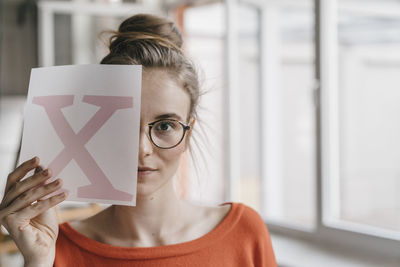 Portrait of woman holding eyeglasses