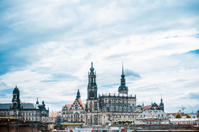 View of buildings in city against cloudy sky